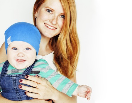 young beauty mother with cute baby, red head happy modern family smiling isolated on white background close up, lifestyle people conceptの写真素材