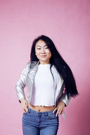 young pretty smiling asian korean girl wearing modern fashion clothers on pink background, lifestyle people conceptの写真素材