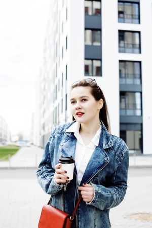 young pretty hipster girl student with coffee cup posing adorable smiling, lifestyle people concept outdoorの写真素材