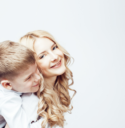 young modern blond mother with cute son together happy smiling family posing cheerful on white background, lifestyle people concept, sister and brother friendsの写真素材