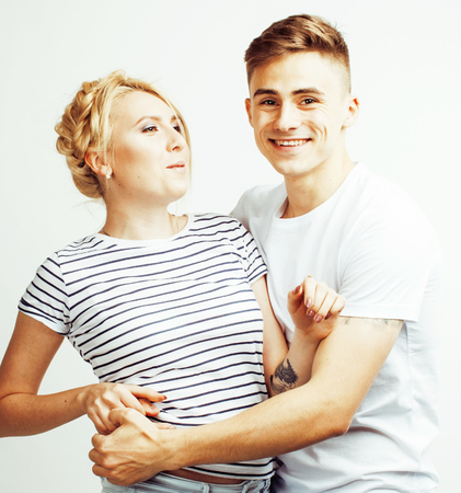 young pretty teenage couple, hipster guy with his girlfriend happy smiling and hugging isolated on white background, lifestyle people conceptの写真素材