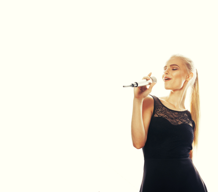 young pretty blond woman singing in microphone isolated close up karaoke singerの写真素材