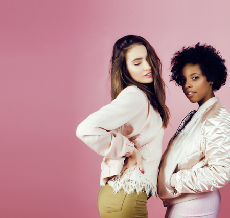 different nation girls with diversuty in skin, hair. Asian, scandinavian, african american cheerful emotional posing on pink background, woman day celebration, lifestyle people concept close upの写真素材