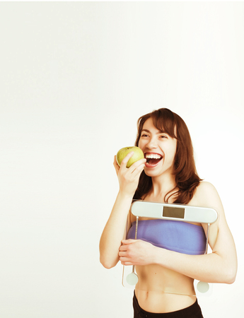 portrait of young smiling girl with green apple and scalesの写真素材