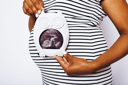 african american woman pregnant , posing on white background isoの写真素材