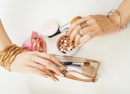 woman hands with golden manicure and many rings holding brushes,の写真素材