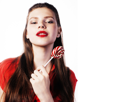 young pretty brunette girl with red candy posing on white backgrの写真素材