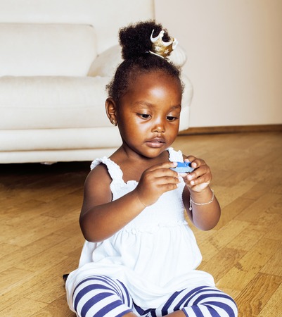 little cute african american girl playing with animal toys at homeの写真素材