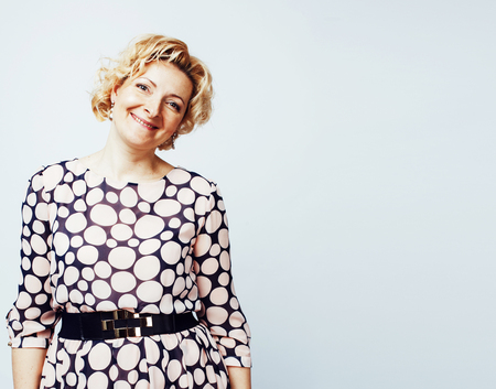 mature blond curly woman cheerful posing on white backgroundの写真素材