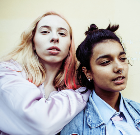 Two teenage girls infront of university building smilingの写真素材