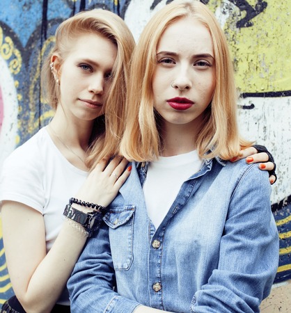 Two teenage girls infront of university building smiling, havingの写真素材