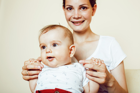 young brunette happy mother holding toddler baby son, breast-feeの写真素材