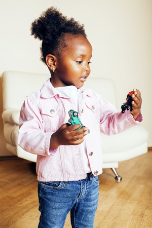 little cute african american girl playing with animal toys at hoの写真素材