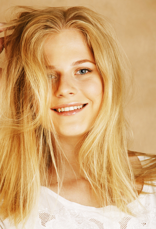 young cool blong teenage girl messed with her hair smilingの写真素材