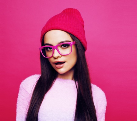young pretty teenage woman emotional posing on pink background,の写真素材