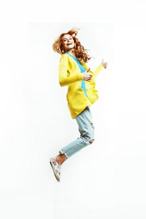 pretty young redhad teenage girl  jumping happy smiling on whiteの写真素材