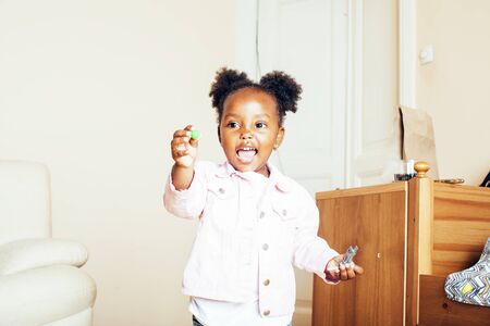 little cute african american girl playing with animal toys at homeの写真素材