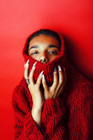 young pretty indian girl in red sweater posingの写真素材