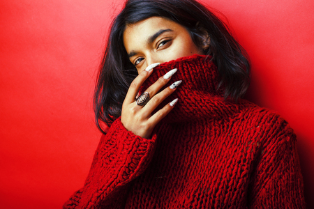 young pretty indian girl in red sweater posing emotional, fashioの写真素材