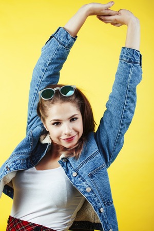 lifestyle people concept: pretty young school teenage girl having fun happy smiling on yellow background close upの写真素材
