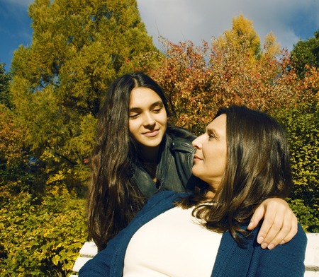 mature real mother with daughter outside autumn fall in park smilingの写真素材