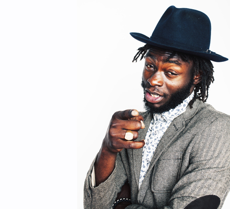 young handsome afro american boy in stylish hipster hat gesturing emotional isolated on white...