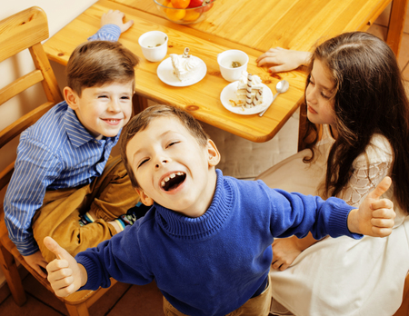 little cute boys eating dessert on wooden kitchen. home interior. smiling adorable friendship together forever friends, lifestyle people concept close upの写真素材