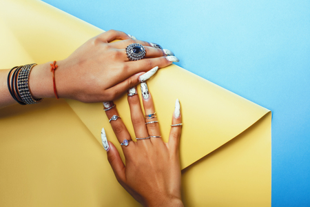 woman hands holding colorful paper copyspace wearing a lot of jewelry and long nailsの写真素材