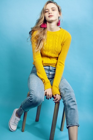 young pretty teenage modern hipster girl posing emotional happy on blue background, lifestyle people conceptの写真素材