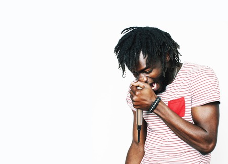 young handsome african american boy singing emotional with microphone isolated on white background, in motion gesturing smiling close up. karaoke singerの写真素材