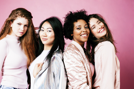 different nation girls with diversuty in skin, hair. Asian, scandinavian, african american cheerful emotional posing on pink background, woman day celebration, lifestyle people concept close upの写真素材