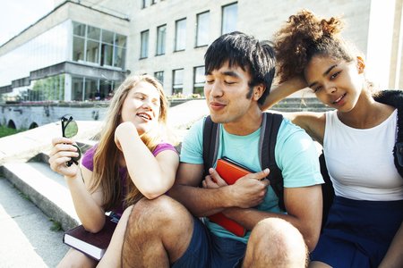 cute group of teenages at the building of university with books huggings, diversity nations students lifestyleの写真素材