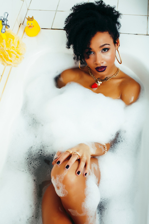young pretty african american girl taking bath with foam, lifestyle people conceptの写真素材