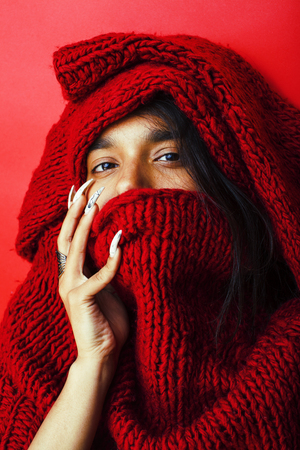 young pretty indian girl in red sweater posing emotional, fashion hipster teenage, lifestyle people concept close upの写真素材