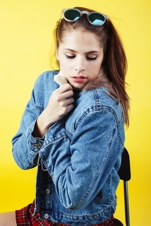 lifestyle people concept: pretty young school teenage girl having fun happy smiling on yellow background close upの写真素材