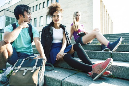cute group of teenages at the building of university with books huggings, diversity nations real students lifestyleの写真素材