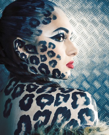young sexy woman with leopard make up all over body, cat bodyart print close upの写真素材