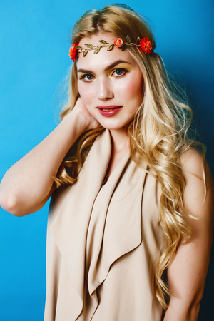 young blond woman dressed like ancient greek godess, jewelry close up isolated, beautiful girl hands manicured red nails on blue background copyspaceの写真素材
