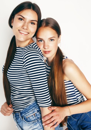 best friends teenage girls together having fun, posing emotional on white background, besties happy smiling, lifestyle people conceptの写真素材