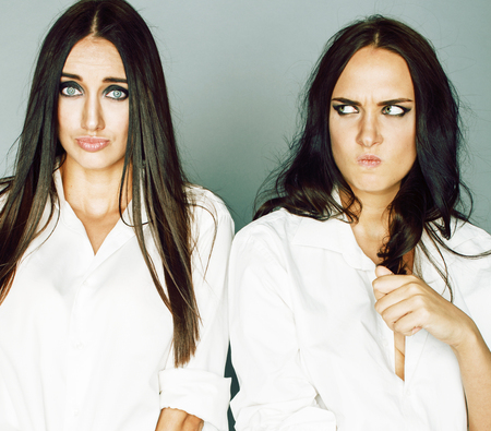 two sisters twins posing, making photo selfie, dressed same white shirt, diverse hairstyle friends, lifestyle people conceptの写真素材