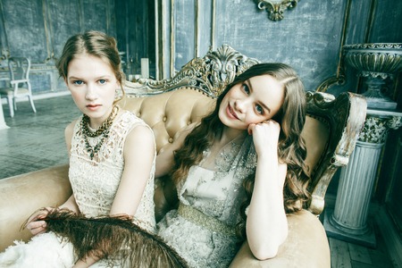 two pretty twin sister blond curly hairstyle girl in luxury house interior together, rich young...
