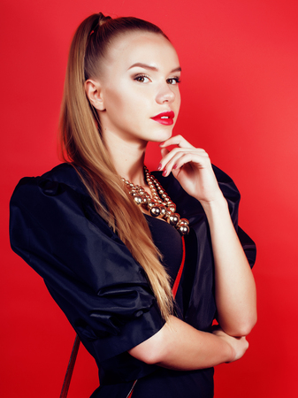 young pretty woman young lady posing on red background, lifestyle people concept close upの写真素材