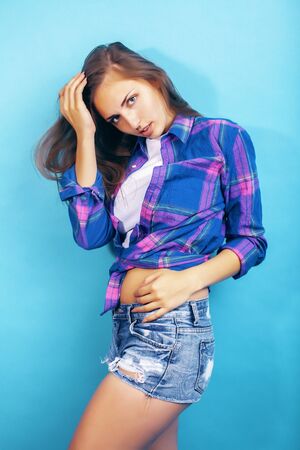 young pretty girl posing happy smiling on blue background, lifestyle people on summer vacation conceptの写真素材