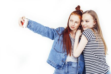 two best friends teenage girls together having fun, posing emotional on white background, besties happy smiling, making selfie, lifestyle people conceptの写真素材