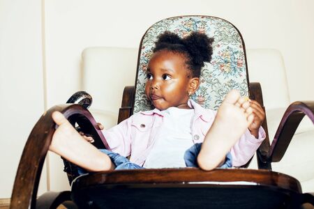little cute african american girl playing with animal toys at home, pretty adorable princess in interior happy smiling, lifestyle people concept close upの写真素材