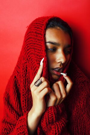 young pretty indian girl in red sweater posing emotional, fashion hipster teenage, lifestyle people concept close upの写真素材