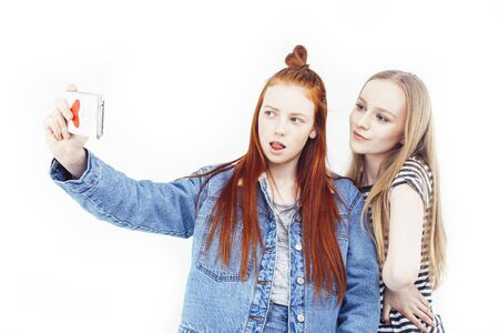 two best friends teenage girls together having fun, posing emotional on white background, besties happy smiling, making selfie, lifestyle people conceptの写真素材