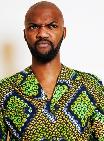 portrait of young handsome african man wearing bright green national costume smiling gesturing, entertainment stuffの写真素材