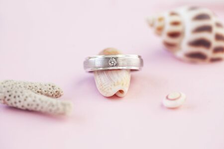 beautiful macro shot of golden wedding ring with some stuff on colored backgroundの写真素材