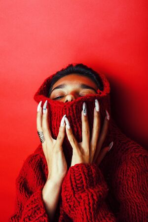 young pretty indian girl in red sweater posing emotional, fashion hipster teenage, lifestyle people concept close upの写真素材